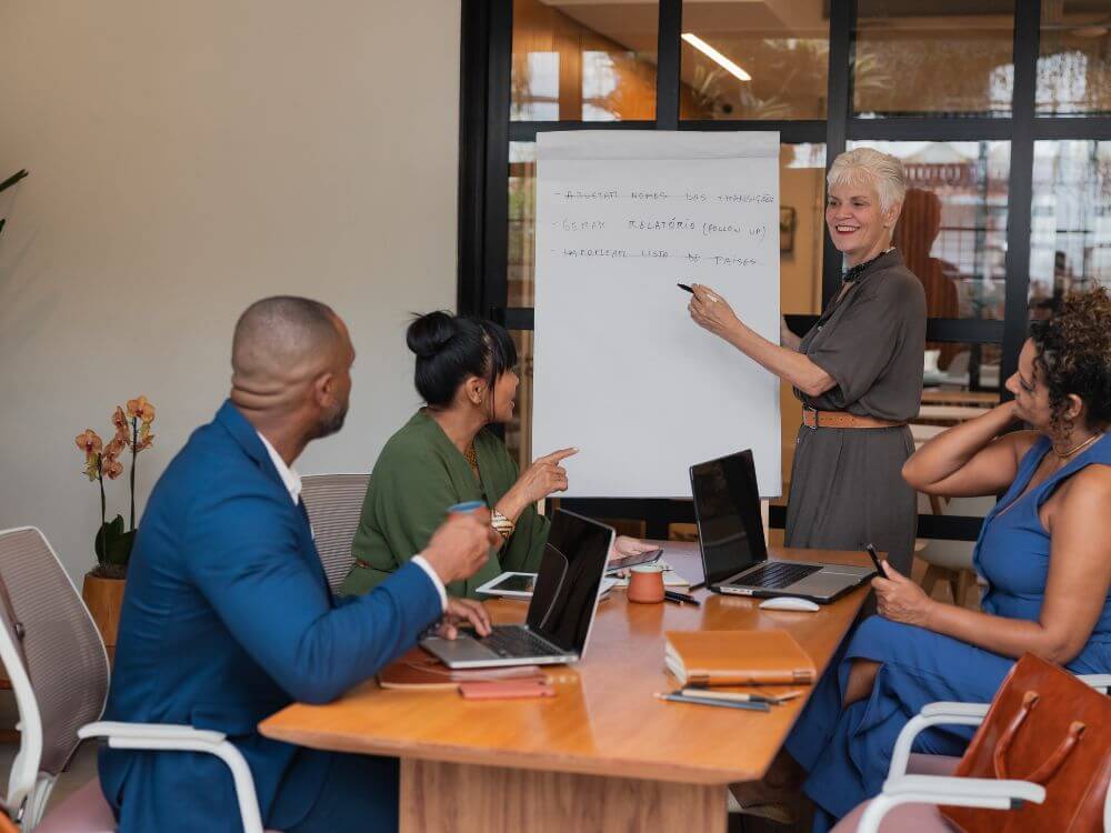 Equipe reunida em apresentação corporativa, representando criatividade, planejamento e brainstorming para definir nomes criativos para empresas de decoração de festas.