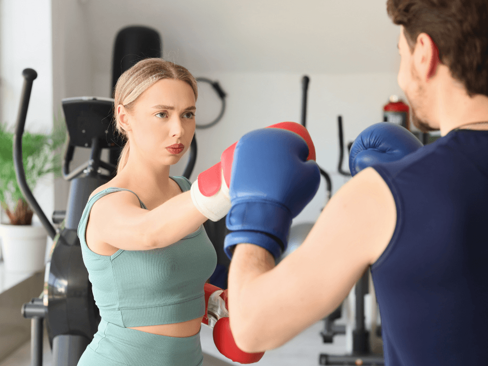 Homem e mulher em academia, fazendo aula de box