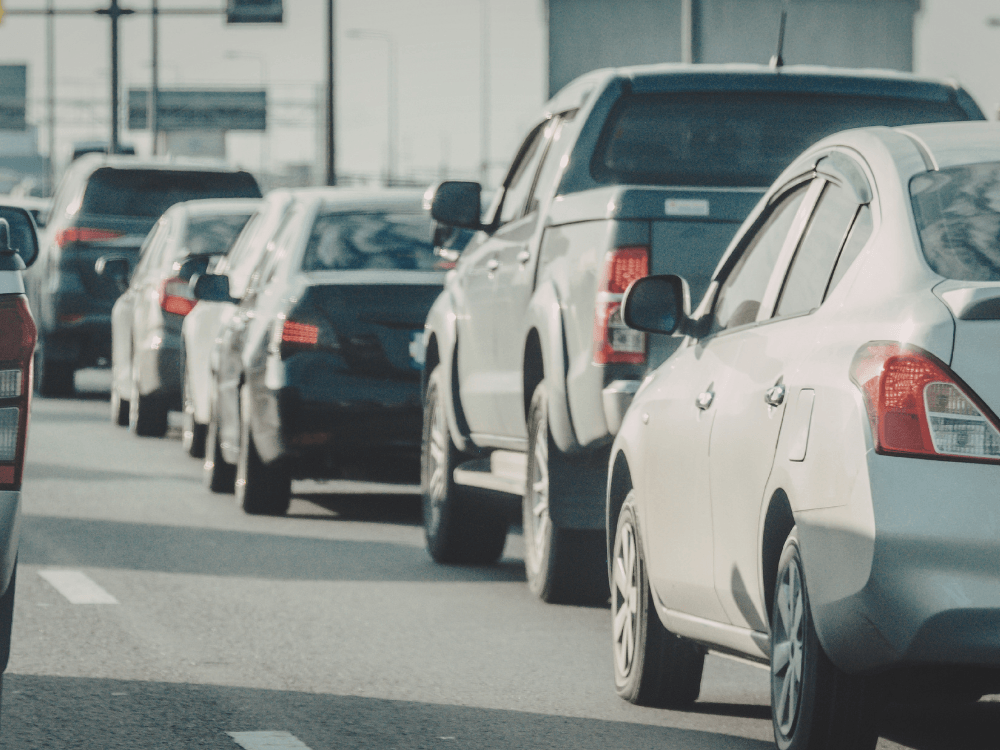 Imagem de capa de trânsito em região urbana, com vários carros em fila